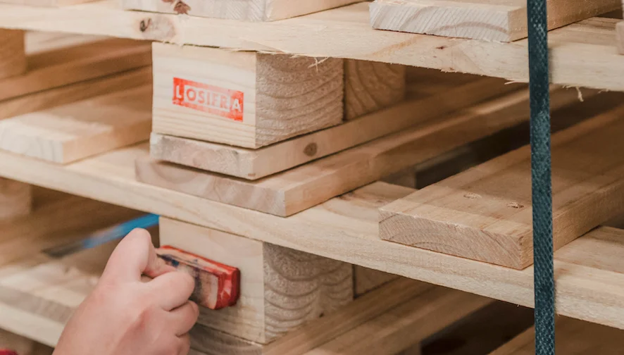 Tarimas de madera siendo selladas con el nombre de Losifra